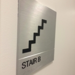 solid aluminum with a V grove cut in the sign with stainless Steel Grade 2 Braille